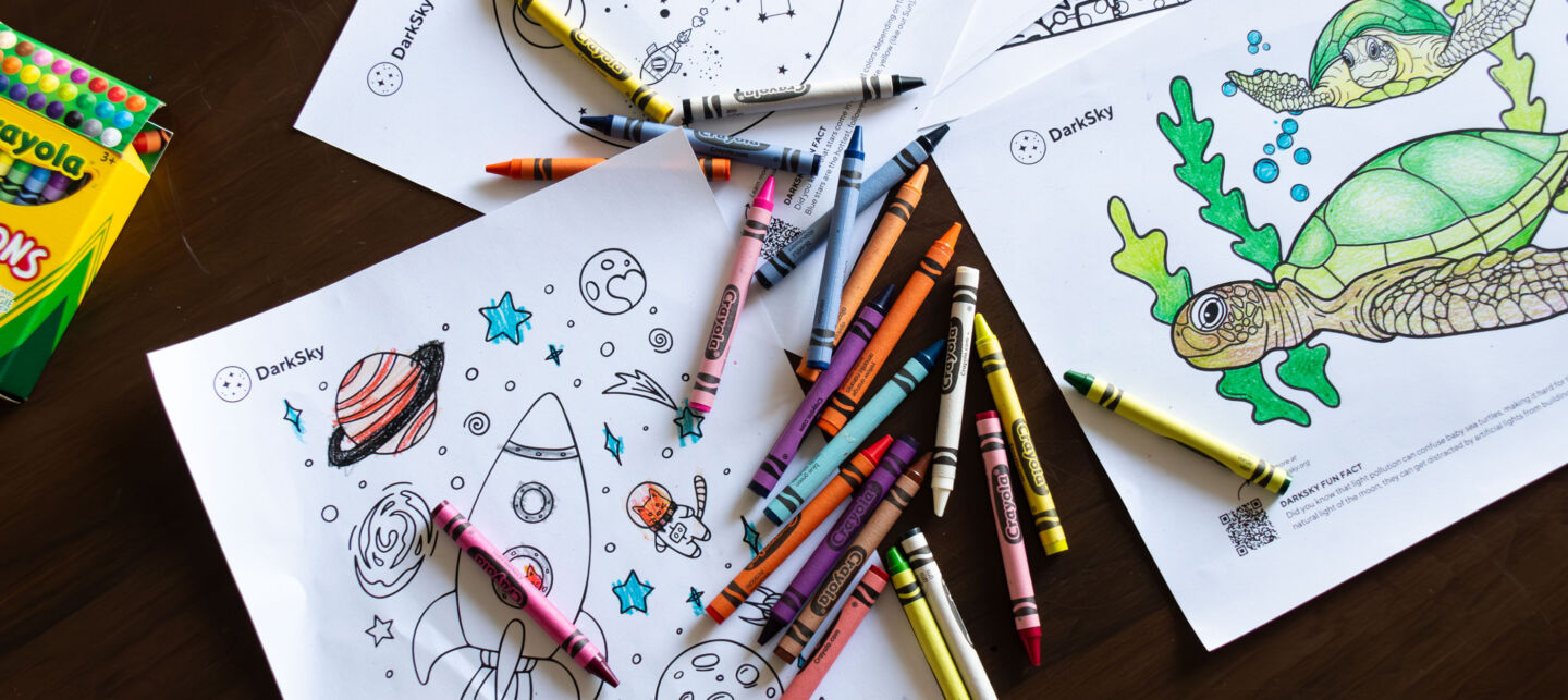 A pile of crayons on top of coloring pages.